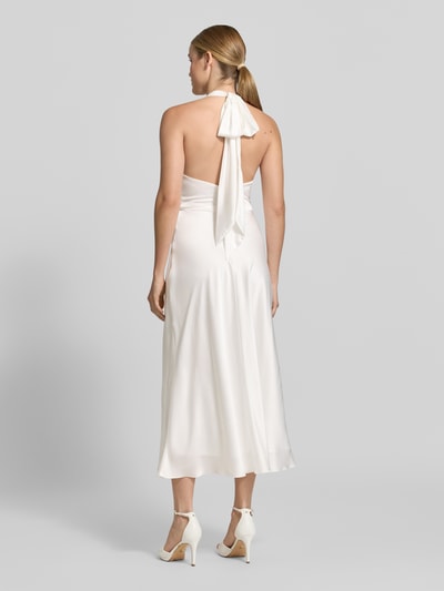 Frauenmodel trägt Slim Fit Midikleid aus Satin von Hey Kyla in Weiß mit Raffung, Rückenausschnitt, Neckholder, Ganzkörperansicht Rückansicht.