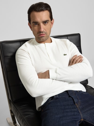 Männermodel trägt Regular Fit Langarmshirt aus Baumwoll-Mix Modell 'SERAFINO' von Lacoste in Optik: Unifarben mit Logo-Stitching, Nahaufnahme Oberkörper.