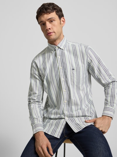 Männermodel trägt Freizeithemd mit Knopfleiste von Fynch-Hatton aus reiner Baumwolle, Regular-Fit, mit Button-Down-Kragen, Brusttasche, Label-Stitching, gestreift in Weiß und Grün, Ganzkörperansicht von vorne.