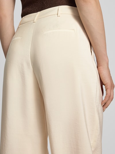 Kobiece modelka ma na sobie Relaxed Fit Hose mit eingefassten Beinabschlüssen von Christian Berg Woman Selection, mieszanka modalu, zakładki w pasie, kieszenie z tyłu, zapięcie na guzik i zamek błyskawiczny, szerokość w rozmiarze 36: 40 cm, długość wewnętrzna nogawki w rozmiarze 36: 70 cm, jasny beżowy kolor, lekko połyskująca tekstura, delikatny materiał, detal tylnej części spodni, zbliżenie na pośladki, detalaufnahme.