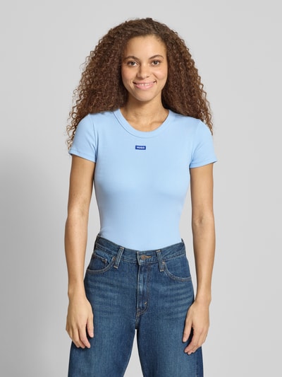 Kobiece modelka nosi damski t-shirt Slim Fit T-Shirt aus Baumwoll-Mix Modell 'EASY TEE' od HUGO BLUE, efekt: jednolity kolor, aplikacja: naszywka z logo, wykończenie materiału: prążkowanie, materiał: mieszanka bawełny, okrągły dekolt, krótki rękaw, ujęcie: całkowity widok z przodu.