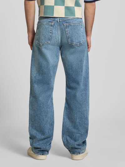 Männermodel trägt Regular Fit Jeans aus reiner Baumwolle von Calvin Klein Jeans, blaue Denim-Optik, 5-Pocket-Design, Ganzkörperansicht Rückansicht.