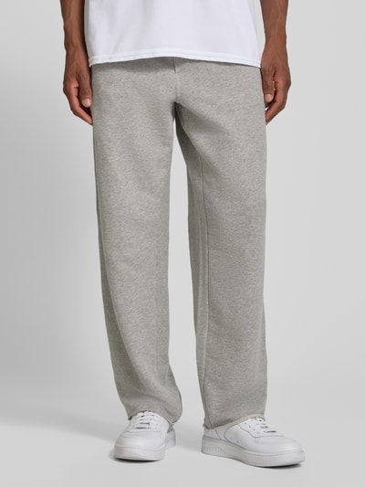 Männermodel trägt Sweatpants mit Eingrifftaschen Modell 'NYZZOW' von American Vintage aus Baumwoll-Elasthan-Mix, Wide Leg, Ganzkörperansicht von vorne.