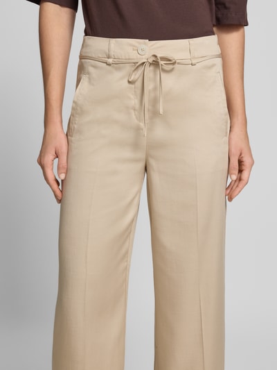 Kobiece model prezentuje Wide Leg Pants mit Bindegürtel Modell 'Meeri bloom' od OPUS, lyocell z domieszką bawełny, szerokie nogawki, jasny beż, francuskie kieszenie, pasek, guziki, widok z przodu, zbliżenie na górną część.