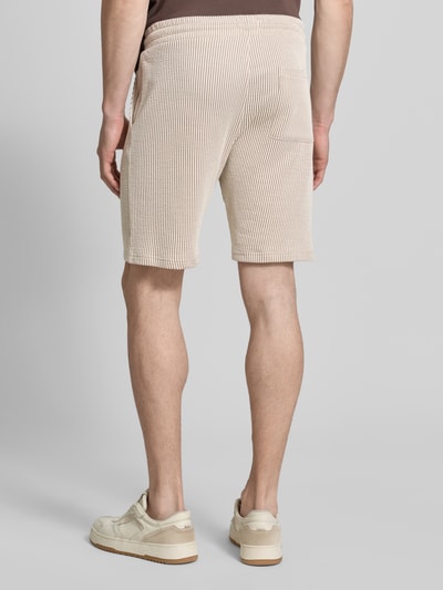 Männermodel trägt Shorts mit elastischem Bund und Kordelzug von MCNEAL aus Baumwoll-Mix, Loose-Fit, cremefarben, Ganzkörperansicht Rückansicht.
