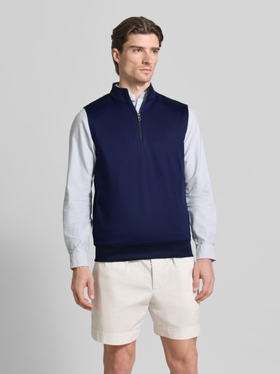 Męski model nosi Regular Fit Troyer bez rękawów model 'NEW LUX' od Polo Ralph Lauren, jednolity granatowy jersey, krój regular fit, pas z prążkami, krótki zamek, aplikacja z logo, widok całej sylwetki z przodu.
