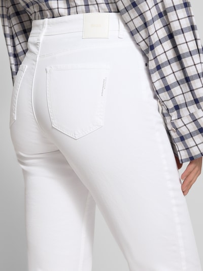Kobiece modelka nosi Flared Fit Stoffhose mit Lyocell-Anteil Modell 'Carola' od Brax, biała tkanina, pięć kieszeni, Szerokość w rozmiarze 36K: 37 cm, długość nogawki: 75 cm, zdjęcie z tyłu, zbliżenie na biodra