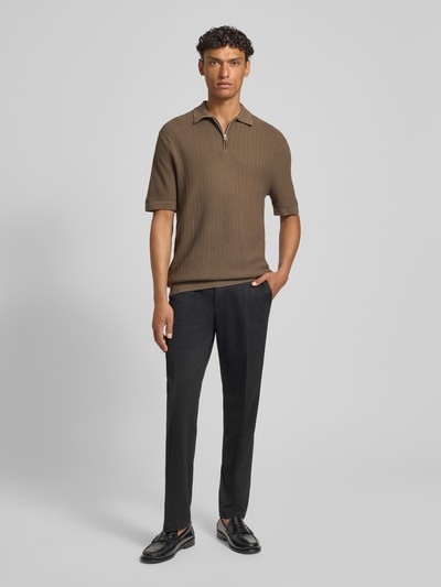 Männermodel trägt Regular Fit Poloshirt aus reiner Bio-Baumwolle Modell 'CRAN' von SELECTED HOMME in Strickoptik mit Struktur, Ganzkörperansicht von vorne.