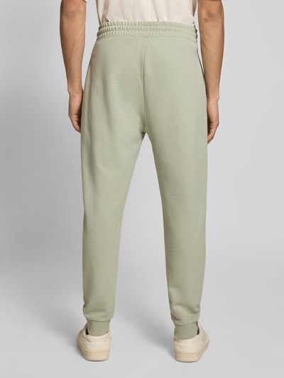 Männermodel trägt Relaxed Fit Sweatpants aus reiner Baumwolle Modell 'NAPIN` von Hugo Blue, Optik: Unifarben, Ganzkörperansicht Rückansicht.