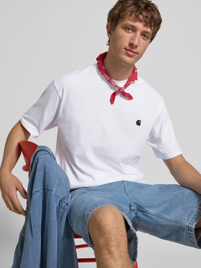 Männermodel trägt Herren T-Shirt mit Label-Stitching Modell 'Madison' von Carhartt Work In Progress, Reine Baumwolle, weiß, Regular-Fit, Rundhalsausschnitt, Rückenlänge bei Größe M 75 cm, Ganzkörperansicht von vorne.