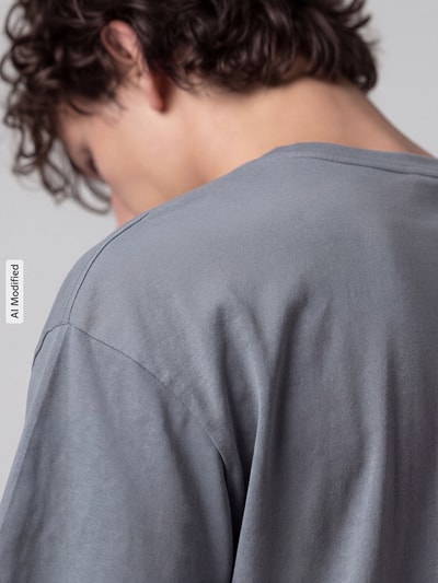 Männermodel trägt Oversized Sport-T-Shirt aus Baumwoll-Mix Modell 'UA M HWT GRADIENT' von Under Armour, graue Farbe, Nahaufnahme Rücken, Herren Sport-T-Shirt von Under Armour, KI-modifiziertes Bild.