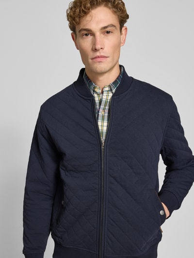 Mężczyzna nosi Regular Fit Sweatjacke aus Baumwoll-Mix von GANT w kolorze granatowym, tekstura pikowana, zamek z przodu, Nahaufnahme Oberkörper.