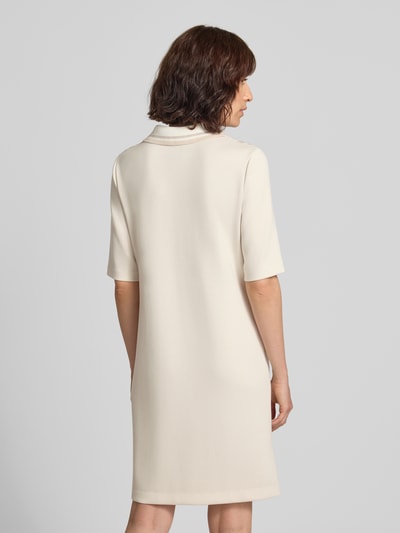 Frauenmodel trägt Polokleid im Allover-Look mit Knopfleiste von Marc Cain in Creme, glatte Struktur, gerader Schnitt, Ganzkörperansicht Rückansicht, Viskose-Mix mit Bio-Baumwoll-Anteil, Minikleid.