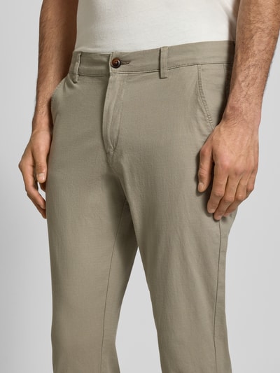 Männermodel trägt Straight Fit Stoffhose aus Baumwoll-Mix Modell 'MARCO FURY' von JACK & JONES, beige, Nahaufnahme Hüftbereich. Herren Stoffhose, Baumwoll-Elasthan-Mix, Knopf- und Reißverschluss, Eingriff- und Gesäßtaschen, Bundweite 44 cm, Innenbeinlänge 77 cm.