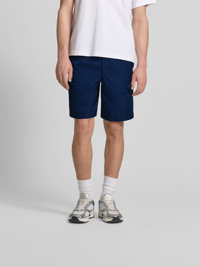 Männermodel trägt Regular Fit Shorts mit Cargotaschen von Kenzo in Dunkelblau, elastischer Bund mit Tunnelzug, Ganzkörperansicht von vorne. Innenbeinlänge 42 cm, Bundweite 24 cm, Gesäßtaschen für Herren.