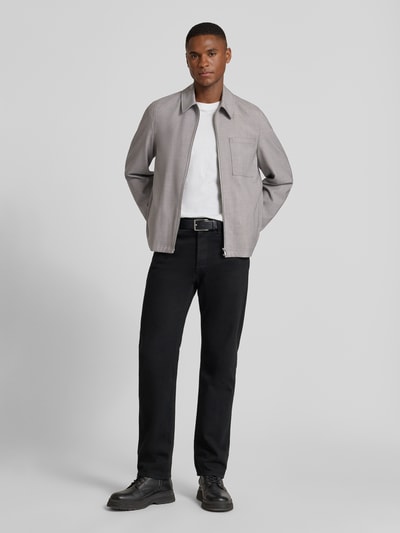 Männermodel trägt Regular Fit Jacke mit Viskose-Anteil Modell 'Jerson' von Drykorn in Grau mit Reißverschluss und Brusttasche, Ganzkörperansicht von vorne, elastischer Material-Mix, glatte Textur, sportliche Details, klassische Form.