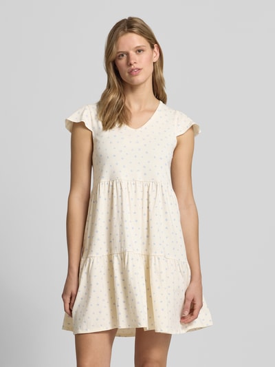 Frauenmodel trägt Minikleid im Stufen-Look mit V-Ausschnitt von REVIEW aus Baumwoll-Elasthan-Mix, A-Linie, creme mit dezentem Muster, Nahaufnahme Oberkörper.