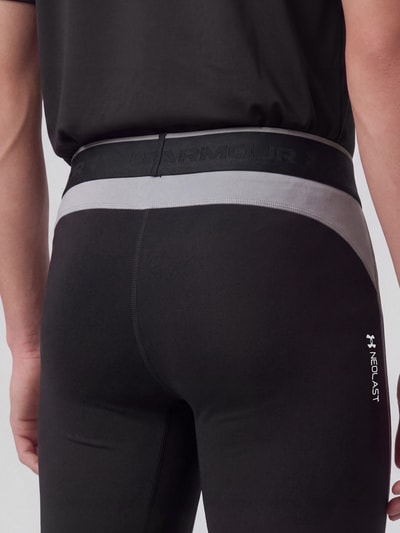 Männermodel trägt Slim Fit Sportshorts mit Logo-Print von Under Armour in Schwarz mit grauem Bund, Nahaufnahme Rückansicht. Herren Sportshorts von Under Armour.