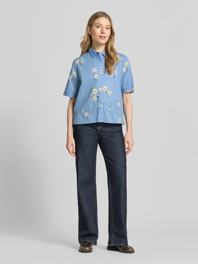 Frauenmodel trägt Relaxed Fit Freizeithemd mit floralem Allover-Print Modell 'Bea' von 0039 Italy aus Reine Baumwolle in Blau mit Kurzärmelig, Kentkragen und durchgängiger Knopfleiste, Ganzkörperansicht von vorne.