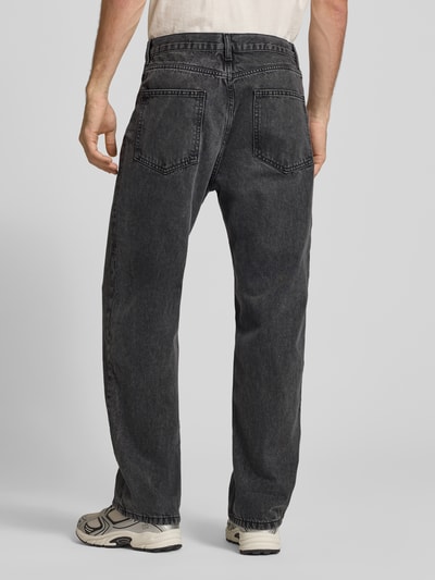 Męski model nosi Baggy Jeans in Grau im klassischen 5-Pocket-Look od REVIEW, szara bawełna, krój baggy, wpuszczane kieszenie, zapięcie na guzik i zamek błyskawiczny, szerokość w rozmiarze 32: 42 cm, długość wewnętrzna nogawki: 77 cm, widok całej sylwetki z tyłu