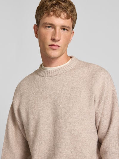 Männermodel trägt Strickpullover mit Rundhalsausschnitt Modell 'SOHO OLLIE' von JACK & JONES, Beige-Ton, Nahaufnahme Oberkörper, Material-Mix mit Woll-Anteil, Regular Fit.