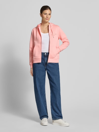 Vrouwenmodel draagt Sweatjacke mit Zweiwege-Reißverschluss und Label-Stitching van Gant in roze, regular fit katoenmix, capuchon met trekkoord, kangoeroezak, voorkant, volledige lichaamsweergave.