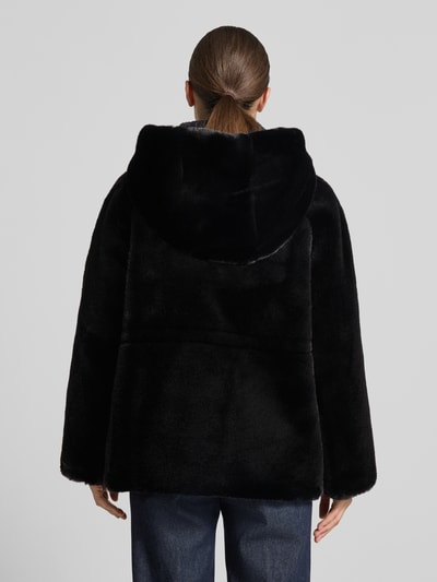 Frauenmodel trägt Kunstfelljacke mit Kapuze von Emporio Armani in Schwarz, glatte Textur, Rückenansicht, Ganzkörperansicht Rückansicht.