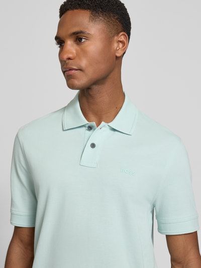 Männermodel trägt Regular Fit Poloshirt aus reiner Baumwolle Modell 'PRIME' von BOSS Orange, Optik: Unifarben, Nahaufnahme Oberkörper.