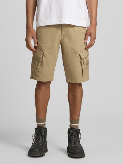 Männermodel trägt Bermudas mit Pattentaschen und Label-Stitchings von PME Legend in Beige, Straight Fit, Motiv-Stitchings, Eingrifftaschen, Knopf-Reißverschluss, Ganzkörperansicht von vorne.