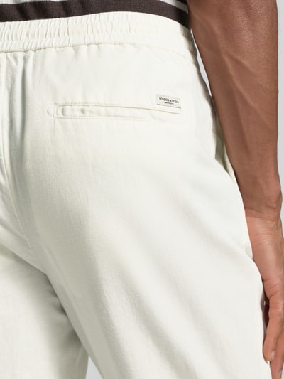 Männermodel trägt Jogpants aus Baumwoll-Leinen-Mix mit elastischem Bund von Scotch & Soda, helle Farbe, Detailaufnahme Rückansicht, Regular Fit, Tunnelzug, Bundweite 42 cm, Innenbeinlänge 76 cm.