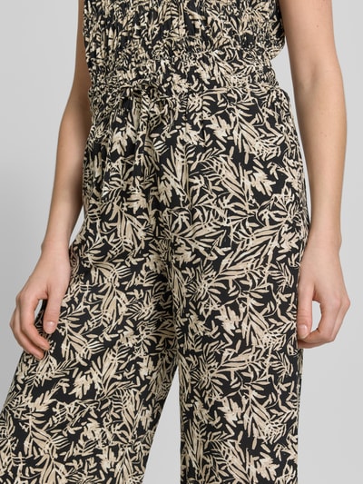 Frauenmodel trägt Straight Fit Stoffhose aus reiner Viskose-Mix Modell 'Faye' von Soyaconcept, floraler Allover-Print, Nahaufnahme Oberkörper. Damen Stoffhose, elastischer Bund mit Tunnelzug, verkürzte Passform, Bundweite 37 cm, Innenbeinlänge 64 cm.