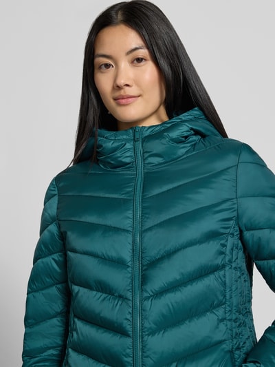 Kobiece model prezentuje Regular Fit Puffer Jacket mit Reißverschlusstaschen od Jake*s Casual, jednokolorowy, kaptur, długi rękaw, wykończenie stebnowane, zamek błyskawiczny, kieszenie zapinane na zamek błyskawiczny, widok z przodu, zbliżenie na górę.