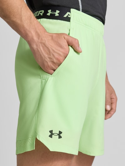 Männermodel trägt Shorts mit elastischem Bund und Logo van Under Armour in lichtgroen met Steekzakken, regular fit, binnenbeenlengte 15 cm, detailaufnahme.