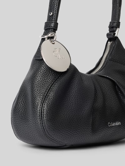 Produktfoto, Henkeltasche mit Label-Prägung Modell 'ENGRAVED HW SMALL BAG' von CK Calvin Klein in Schwarz mit silbernem Logo-Anhänger, strukturierte Lederoptik. Damen Henkeltasche von CK Calvin Klein