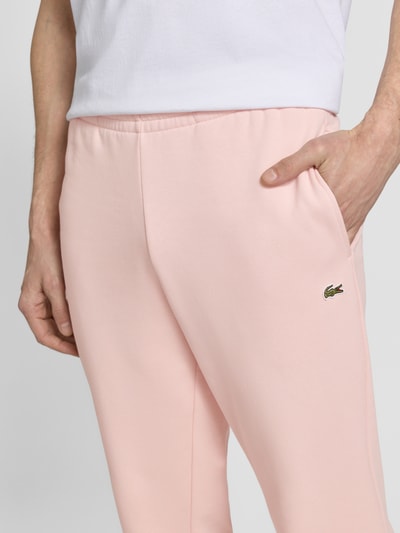 Männermodel trägt Regular Fit Sweatpants aus Baumwoll-Mix von Lacoste, Optik: Unifarben, Logo-Stitching, Nahaufnahme Oberkörper.
