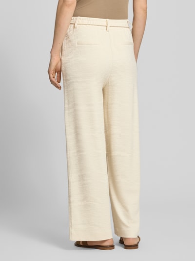 Kobiece model prezentuje spodnie materiałowe Wide Fit Stoffhose aus Viskose-Mix Modell 'Lumina' od ICHI, kremowe, fakturowany wzór, kieszenie z tyłu, odpinana kokarda, szerokość w rozmiarze S: 39 cm, długość wewnętrzna nogawki: 72 cm, widok całej sylwetki z tyłu.