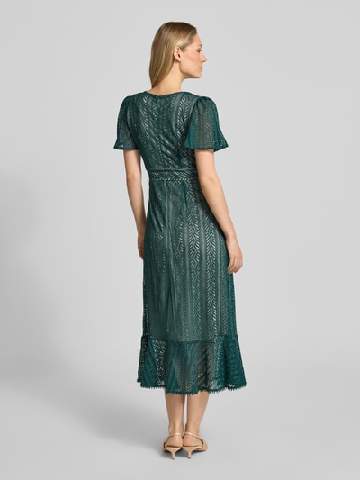 Frauenmodel trägt Kleid mit Häkelspitze von Apricot in dunklem Grün, taillierte Passform, Midilänge, Rückansicht, Ganzkörperansicht.