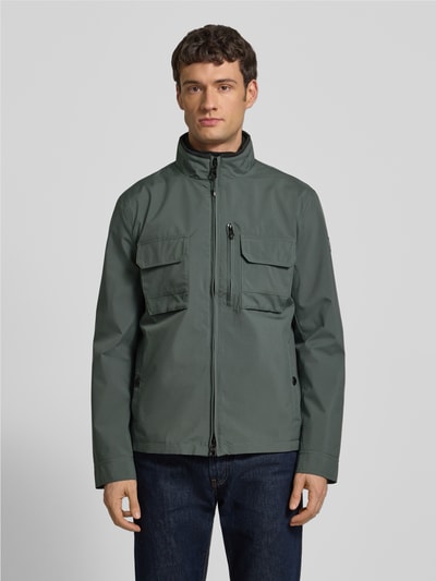 Männermodel trägt Jacke mit Stehkragen von NAUTGÅRD in Regular-Fit mit Reißverschluss, Eingrifftaschen, Brusttaschen, Ganzkörperansicht von vorne. Rückenlänge bei Größe M: 73 cm, Schulterbreite 45 cm, Brustweite 49 cm, Ärmellänge 67 cm.
