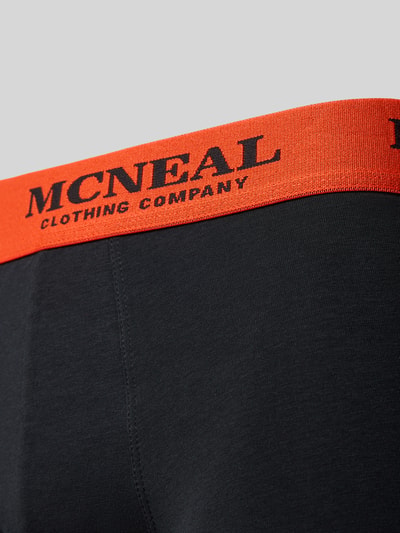 Produktfoto, Boxershorts mit elastischem Logo-Bund im 3er-Pack von MCNEAL aus Baumwoll-Elasthan-Mix, körpernaher Schnitt, schwarze glatte Oberfläche mit orangefarbenem Logo-Bund