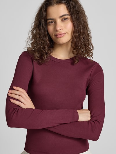 Frauenmodel trägt Slim Fit Langarmshirt aus Baumwoll-Mix Modell 'VAL' von ONLY in Dunkelrot, feine Rippenstruktur, Nahaufnahme Oberkörper. Damen Langarmshirt von ONLY.