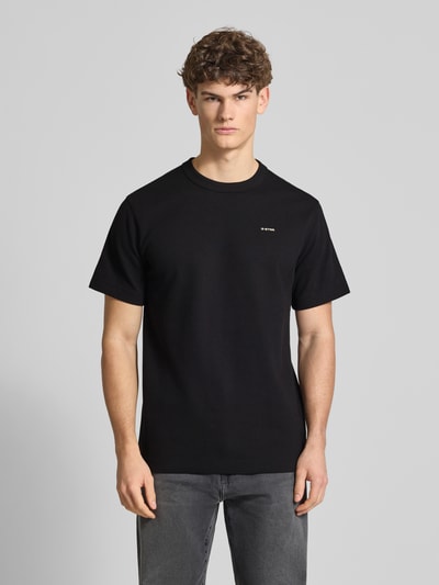 Männermodel trägt Regular Fit T-Shirt mit Strukturmuster von G-Star Raw, schwarz, Rundhalsausschnitt, Logo, Ganzkörperansicht von vorne.