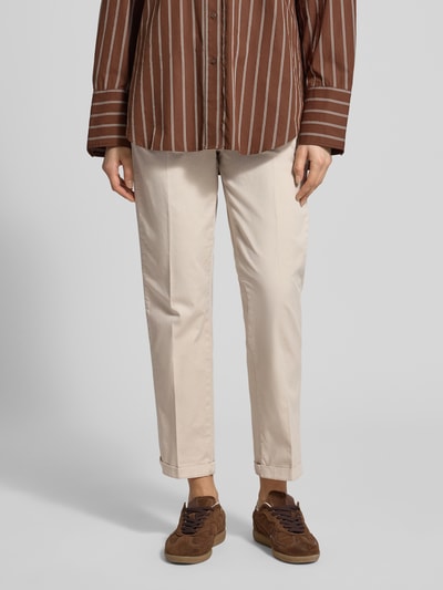 Frauenmodel trägt Chino mit Eingrifftaschen von MAC aus Baumwoll-Elasthan-Mix, Regular Fit, Beige, Nahaufnahme Unterkörper, Vorderansicht.