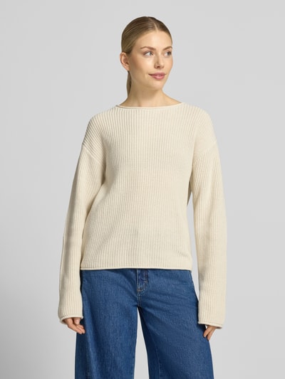 Frauenmodel trägt Relaxed Fit Strickpullover aus Baumwoll-Mix von s.Oliver RED LABEL in Beige mit Rippstruktur und blauen Jeans, Ganzkörperansicht von vorne.