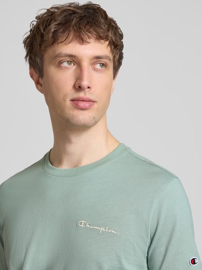 Männermodel trägt T-Shirt mit Label-Stitchings und Rundhalsausschnitt von CHAMPION in Hellgrün, reine Baumwolle, Regular Fit, Nahaufnahme Oberkörper.