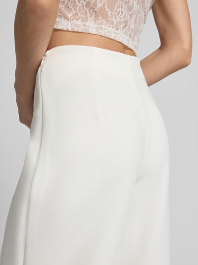 Frauenmodel trägt Straight Fit Stoffhose mit Viskose-Anteil Modell 'Leonie' von GUIDO MARIA KRETSCHMER WOMAN, Elastischer-Material-Mix, weites Bein, Ziernähte, cremeweiße Textur, Detailaufnahme Hüfte.