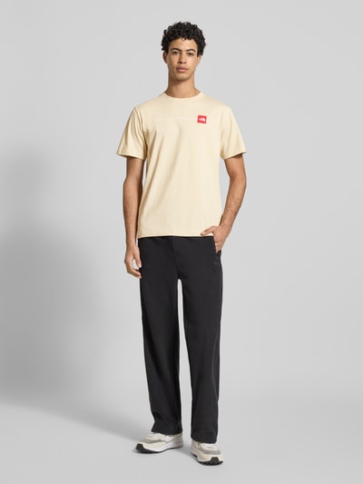 Männermodel trägt Regular Fit T-Shirt mit Logo-Print von The North Face aus Baumwoll-Mix, Rundhalsausschnitt, Rückenlänge 70 cm, Ganzkörperansicht von vorne.