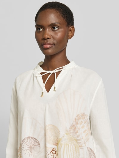 Kobiece modelka ma na sobie Relaxed Fit Bluse mit Schnürung von Marc Cain z bawełny, wzór na całej powierzchni, wiązanie, nahaufnahme górnej części ciała.