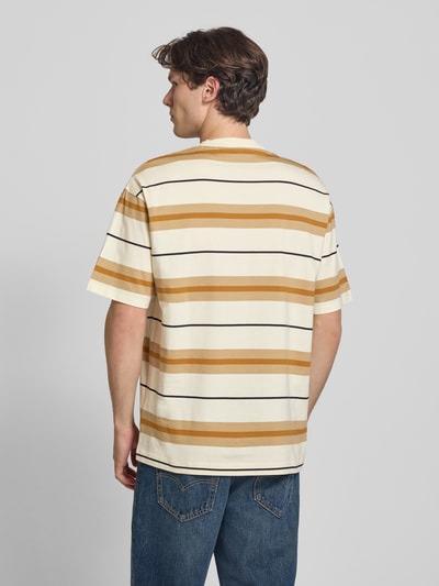 Mannmodel draagt oversized shirt van katoen model 'NIVARSI' van HUGO in crèmekleur met mosterdgele en zwarte strepen, heren, geheellichaamsaanzicht achteraan.