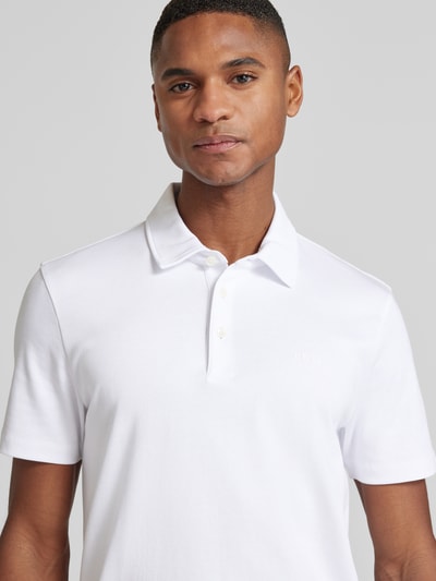 Männermodel draagt Poloshirt met Brand-Schriftzug van BOSS, witte katoenen regular fit, korte mouwen, tonale branding, Nahaufnahme bovenlichaam.