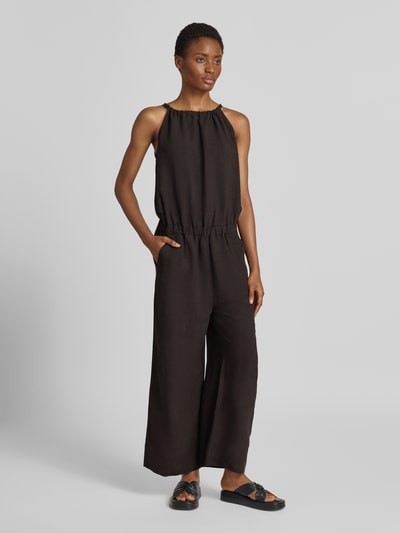 Männermodel trägt Jumpsuit mit rückseitiger Schnürung Modell 'Cisea' von someday., czarny, lekko luźny krój regular fit, z mieszanki wiskozy i lnu, okrągły dekolt, szerokie nogawki, gładka tekstura, Szerokość w rozmiarze 36: 46 cm, długość pleców 135 cm, długość całkowita 124 cm, długość nogawki wewnętrznej 63 cm, Ganzkörperansicht von vorne.